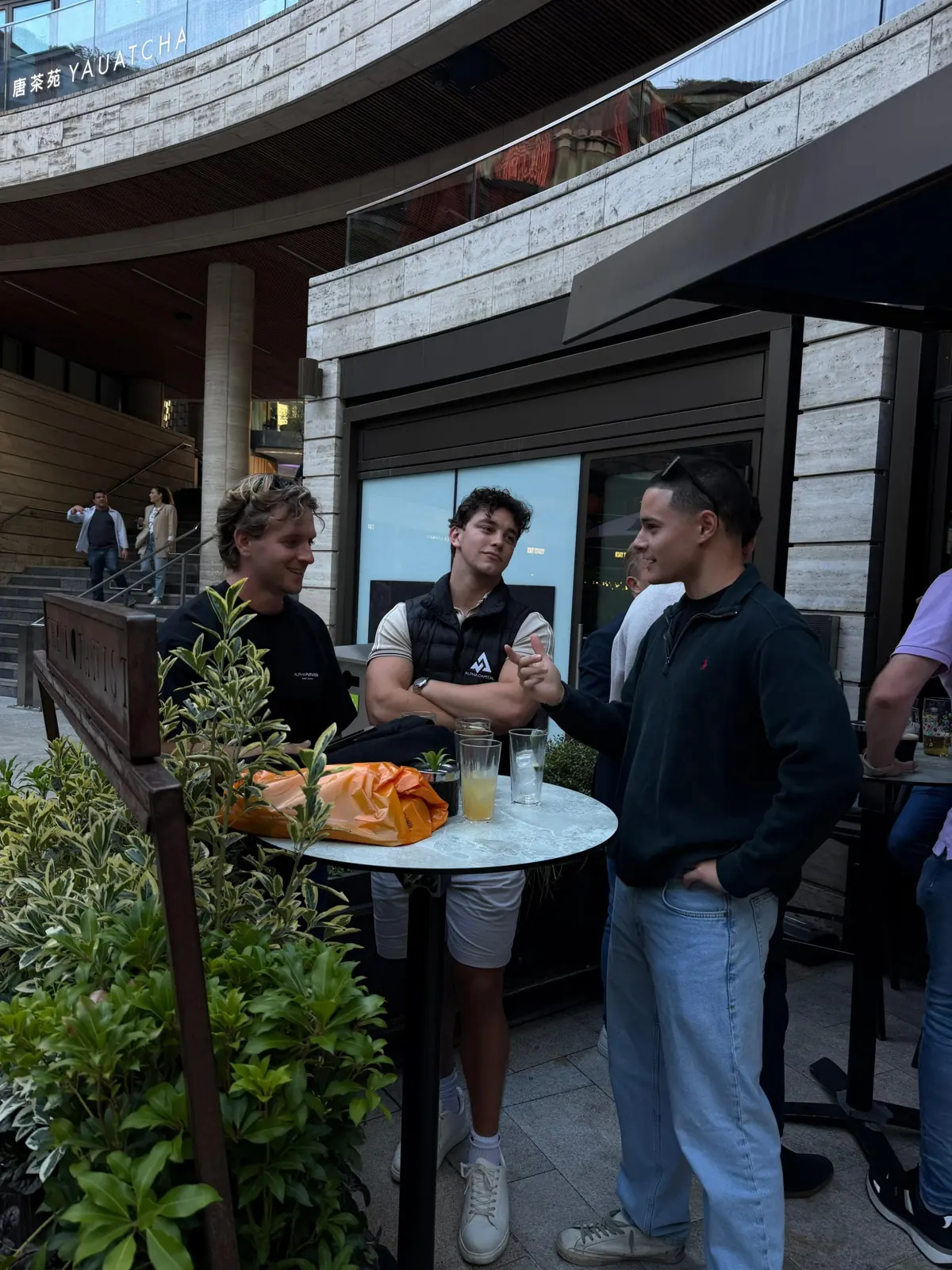 A small group meeting up around an outdoor table